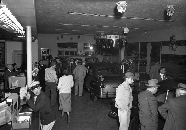 Crowd and counter in Wilson Motor Co. Showroom __ John Hensel Photograph Collection